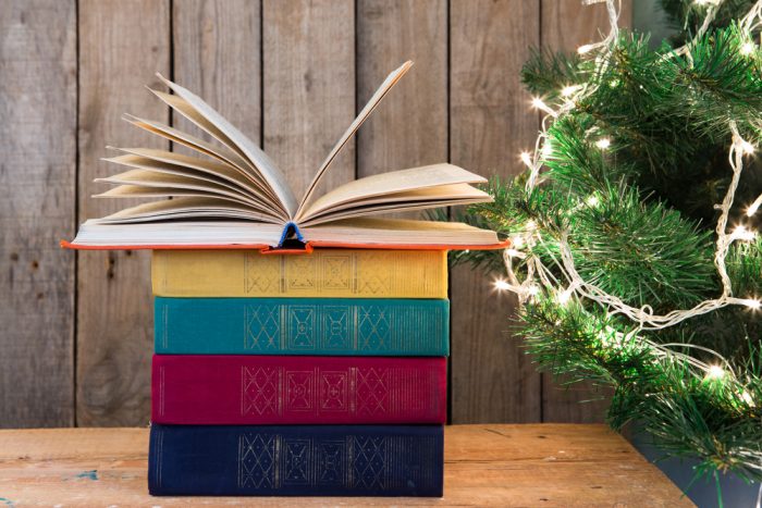 Old books and Christmas tree on the wooden background